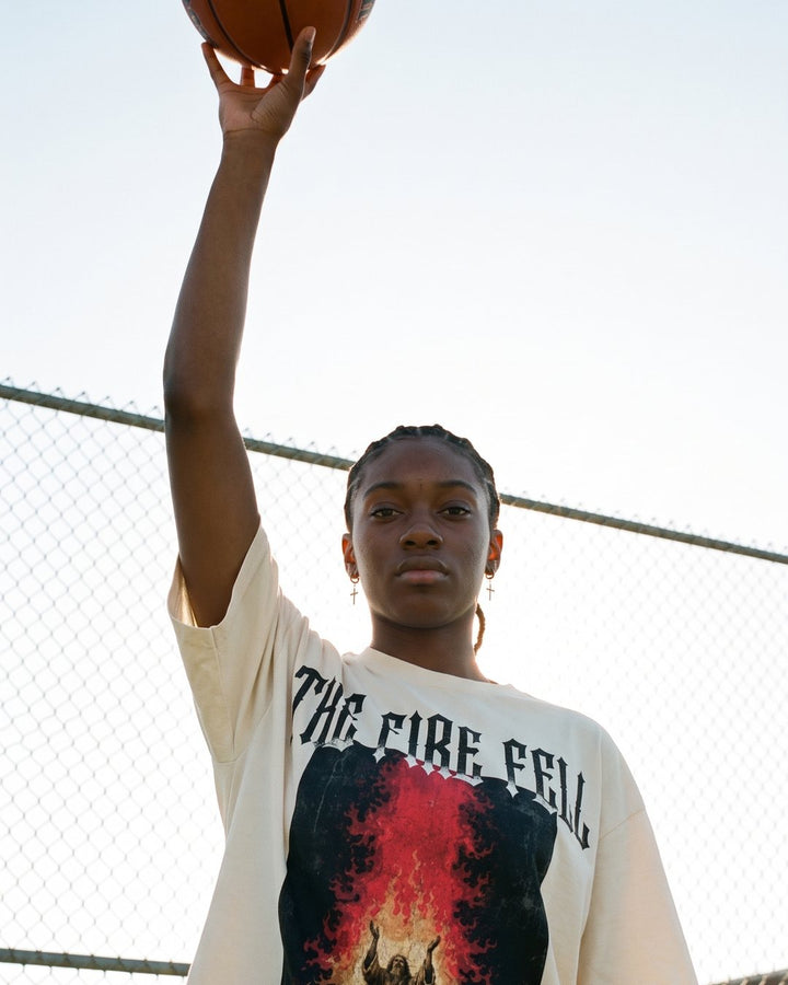 Model wearing the NaskiCo The Fire Fell streetwear tee on the court, 1 Kings 18:38